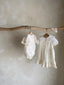 Meisje kinderkleding Jeanne jurkje van stevig katoen in creme met schattige strikjes en volants 2 - 4 jaar peuter hangend