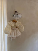 bloesje voor baby's en kinderen met een vrolijk subtiel bloemenprintje en grote kraag hangend met een liefelijk bloomerrokje