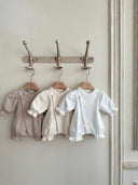 newborn pakjes hangend aan kapstok in de kleuren indi pink creme en wit voor pasgeboren baby's 