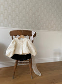 ivoor kleurig net zomerjasje voor baby's en kinderen gemaakt van een bewerkte stof met pofmouwtjes en knoopjes