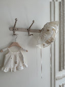 Aimee bloomer rokje van katoen in creme met geborduurde bloemen en elastische tailleband met verstelbare schouderbandjes hangend vooraanzicht samen met bijpassende Aimee top met dezelfde embroidery bloemen