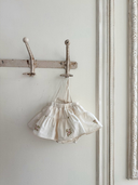 Aimee bloomer rokje van katoen in creme met geborduurde bloemen en elastische tailleband met verstelbare schouderbandjes hangend vooraanzicht