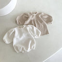 amy rompertje voor baby's en dreumes van 12 en 18 maanden van gewafelde katoenen stof met pofmouwtjes kanten randje langs de hals en knoopjes onderaan liggend vooraanzicht