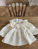 Baby meisje Alba wijd uitlopende blouse in creme/ecru met volant kraag en bloemenmotief voor baby's en kindjes van 6 tot 18 maanden liggend 
