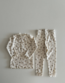 Baby meisje Celina legging van geribbeld zacht katoen in creme met bloemenprint en omgeslagen pijpje en strikje met bijpassende celina top liggend bovenaanzicht 