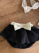 Baby meisje Louve bloomer rokje in zwart met creme kleurige stik en tailleband voor baby's en dreumes van 3 - 18 maanden vooraanzicht liggend