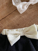 Baby meisje Louve bloomer rokje in zwart met creme kleurige stik en tailleband voor baby's en dreumes van 3 - 18 maanden close up strik