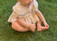 Baby meisje Mia romper jurkje van katoen en mousseline, pofmouwtjes volumineus rokje en strikjes in creme kleur voor baby en dreumes (3 - 24 maanden)