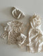 Baby meisje Marie wikkel jurkje/overjurkje schortje van opengewerkt katoen met volantkraag , strik en geborduurde bloemetjes in creme - one size 86/92/98 bovenaanzicht gestyled met celina legging en top met bloemetjes