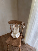 Baby meisje Diana romper van stevig katoen met gesmokt bovenlijfje - Creme (3 - 18 maanden) liggend vooraanzicht