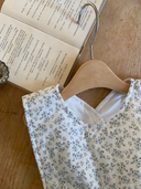 Faye romper zonder mouwen met schattig blauw bloemenprintje close up halslijn liggend