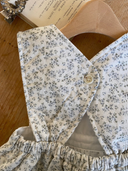 Faye romper zonder mouwen met schattig blauw bloemenprintje close up achterkant met knoopje