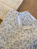 Faye romper zonder mouwen met schattig blauw bloemenprintje close up voorkant hals 