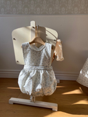 Faye romper zonder mouwen met schattig blauw bloemenprintje hangend aan babybedje