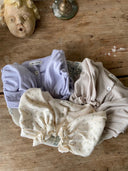 Isabella vestje met pofmouwtjes, elastieke middeltje en knoopje voor baby's van 3 maanden tot 2,5 jaar in drie kleuren lavender, zacht grijs en creme met bloemetjes bovenaanzicht opgevouwen