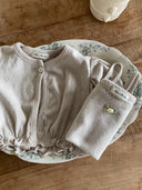Luchtig en charmant katoenen Isabella tanktopje met bijpassende Isabella vestje voor baby's van 3 maanden tot 2,5 jaar met schattig bloemetje voorop, bewerkte randjes en pofmouwtjes in de kleur zacht grijs 
