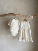 Meisje kinderkleding Jeanne jurkje van stevig katoen in creme met schattige strikjes en volants 2 - 4 jaar  hangend vooraanzicht