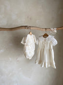 Meisje kinderkleding Jeanne jurkje van stevig katoen in creme met schattige strikjes en volants 2 - 4 jaar peuter hangend