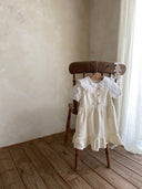 Meisje kinderkleding Jeanne jurkje van stevig katoen in creme met schattige strikjes en volants en blouse 2 - 4 jaar peuter - vooraanzicht