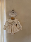 Baby meisje Lilly bloomer rokje van katoen  met geborduurde bloementjes en strikjes in creme kleur maat S 62/68/74 (3 - 10 maanden) en maat M 80/86 (10 - 18 maanden) met de Elisabeth blouse met bloemetjes hangend vooraanzicht