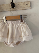 Baby meisje Lilly bloomer rokje van katoen  met geborduurde bloementjes en strikjes in creme kleur maat S 62/68/74 (3 - 10 maanden) en maat M 80/86 (10 - 18 maanden) hangend close up 