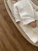 Baby meisje Sera Newborn pakje/geboortepakje van wafel katoen met kanten randjes en bijpassend mutsje maat 62/68 en 74/80 wit close up op baby in mand