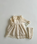 Baby meisje Marie wikkel jurkje/overjurkje schortje van opengewerkt katoen met volant kraag en geborduurde bloemetjes in creme - one size 86/92/98 met celina legging en top liggend bovenaanzicht